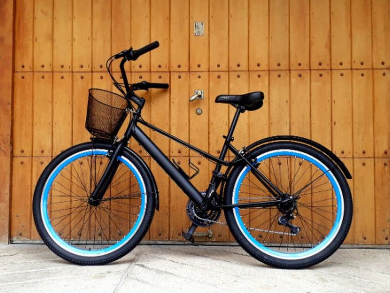 Bicicleta negra con rines azules y canasta